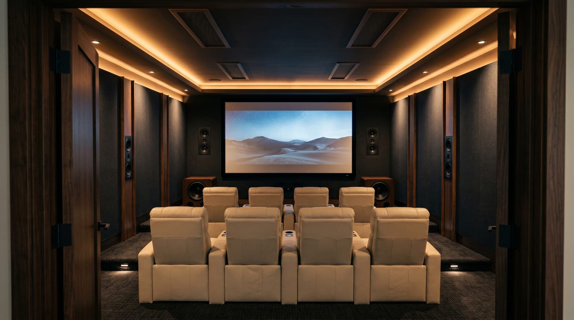 Luxury home theater with tiered leather recliners, tower speakers, and a wide screen